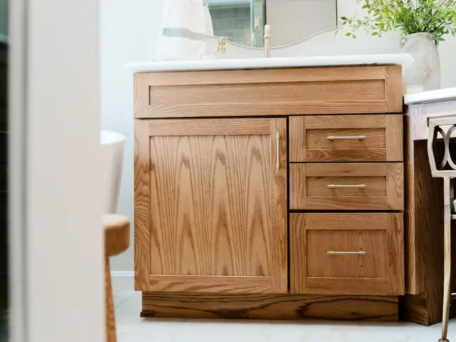 Wood bathroom vanity with a white countertop and paneled cabinet doors.