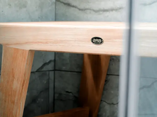 Detail of the wood shower bench against gray wall tile.