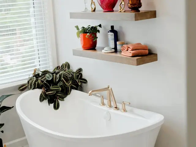 Vertical view of the bathtub and floating shelves next to the bathroom window.