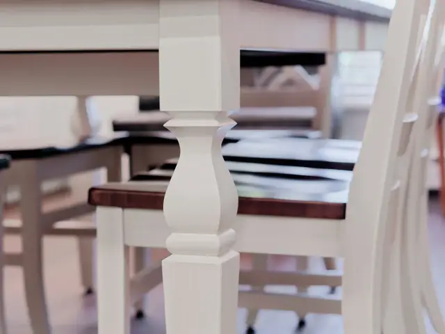 White dining chair with a dark seat beside the kitchen island and beverage counter.